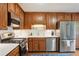 Bright kitchen featuring stainless steel appliances, wood cabinets, white countertops, and a blue rug at 4856 Saddlerun Ln, Powder Springs, GA 30127