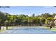 Well-maintained tennis courts enclosed with fencing surrounded by tall trees and exterior building architecture at 4856 Saddlerun Ln, Powder Springs, GA 30127