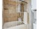 Bathroom features a bathtub with a shower and glass doors, as well as tiled walls at 3481 Lakeside Ne Dr # 1103, Atlanta, GA 30326