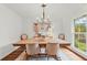 Elegant dining room featuring a wooden table, stylish chandelier, and abundant natural light from a large window at 4855 Kendall Ct, Atlanta, GA 30342