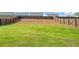 Spacious backyard featuring lush green grass, a gentle slope, and a secure wooden fence at 517 Hyde Ridge Trl, Loganville, GA 30052