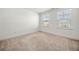Bright bedroom with neutral carpeting and two windows at 517 Hyde Ridge Trl, Loganville, GA 30052