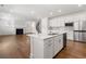 Open concept living with a modern kitchen featuring stainless steel appliances, island, and seamless flow to the living area at 517 Hyde Ridge Trl, Loganville, GA 30052