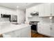 Elegant kitchen featuring quartz counters, stainless appliances, a kitchen island, and white cabinetry at 517 Hyde Ridge Trl, Loganville, GA 30052
