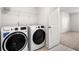 Well-lit Laundry Room with white front-load washer and dryer at 517 Hyde Ridge Trl, Loganville, GA 30052
