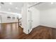 Bright and airy living room featuring hardwood floors, white walls, and a doorway leading to an office space at 517 Hyde Ridge Trl, Loganville, GA 30052