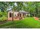 Backyard features a brick patio with outdoor seating, green grass and well maintained landscaping at 2715 Woods Ridge Dr, Alpharetta, GA 30022
