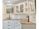 Bathroom featuring dual sinks, granite countertop, and custom glass enclosed wall cabinets at 2715 Woods Ridge Dr, Alpharetta, GA 30022