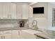 White kitchen featuring updated cabinets, countertops, marble backsplash, and a stainless steel faucet at 2715 Woods Ridge Dr, Alpharetta, GA 30022