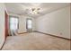 Empty bedroom with neutral walls, carpet, and two large windows with drapes at 3267 Rememberance Trce, Lawrenceville, GA 30044
