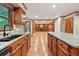 Spacious kitchen with granite countertops, wooden cabinets, and view into open-concept living area at 3267 Rememberance Trce, Lawrenceville, GA 30044