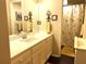 Bright bathroom featuring a large mirror, vanity with sink, and a shower with a yellow floral curtain at 4040 Summit Dr, Marietta, GA 30068