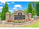 Stone entrance sign for Indian Hills Country Club with manicured flowerbeds and lush greenery at 4040 Summit Dr, Marietta, GA 30068