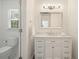 Bright bathroom featuring a vanity with marble countertop, shaker cabinets, and a toilet next to a bright window at 10310 Amberside Ct, Roswell, GA 30076