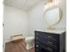 Bathroom with a black vanity, gold hardware, marble countertop, and round mirror that exudes modern elegance at 10310 Amberside Ct, Roswell, GA 30076