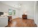 Bedroom with hardwood floors, a ceiling fan, and a view of the trees outside through a large window at 10310 Amberside Ct, Roswell, GA 30076