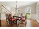 Bright dining room features hardwood floors, chandelier, and elegant window trim, creating a cozy ambiance at 10310 Amberside Ct, Roswell, GA 30076