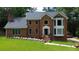 Beautiful brick two-story home featuring a manicured lawn and flowering landscape beds adding curb appeal at 10310 Amberside Ct, Roswell, GA 30076