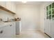 Laundry room with washer, dryer, cabinets, and access to the backyard at 10310 Amberside Ct, Roswell, GA 30076