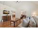 Spacious living room with hardwood floors, paneled walls, and open layout, flowing into other living spaces at 10310 Amberside Ct, Roswell, GA 30076