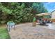 Beautiful backyard patio area with an outdoor dining set, lush greenery, and a charming playhouse at 1411 Primrose Park Rd, Sugar Hill, GA 30518
