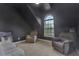 Bedroom with dark walls, a vaulted ceiling, and two comfortable recliner chairs next to a window at 1411 Primrose Park Rd, Sugar Hill, GA 30518