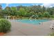 Large community pool featuring lounge chairs, umbrellas, a slide, and lush landscaping in the background at 1411 Primrose Park Rd, Sugar Hill, GA 30518