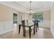 Elegant dining room featuring modern table and chair set, wainscoting, and decorative chandelier at 1411 Primrose Park Rd, Sugar Hill, GA 30518