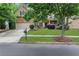 Charming two-story home with brick facade, well-maintained lawn, and a driveway leading to the two-car garage at 1411 Primrose Park Rd, Sugar Hill, GA 30518