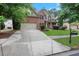 Traditional two-story home featuring a brick facade, manicured lawn, and an attached two-car garage at 1411 Primrose Park Rd, Sugar Hill, GA 30518