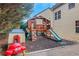 Residential wood playset with slides, climbing wall, and a small plastic playhouse in mulch-covered area at 1411 Primrose Park Rd, Sugar Hill, GA 30518