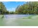 Outdoor tennis court with well-maintained blue surface and green surroundings, set in lush greenery at 1411 Primrose Park Rd, Sugar Hill, GA 30518