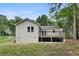 Back view of the home featuring a wooden deck, siding, a spacious backyard, and plenty of shade at 1980 Oakdale Se Ct, Smyrna, GA 30082