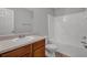 Clean bathroom with white tub/shower combo, a wooden vanity, and neutral flooring at 6032 Trotters Cir, Fairburn, GA 30213
