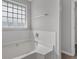 Bathroom showcasing a bright window above the tub and neutral gray walls at 6032 Trotters Cir, Fairburn, GA 30213
