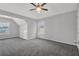 Bright bedroom featuring two windows, gray carpet, and ceiling fan providing natural light at 6032 Trotters Cir, Fairburn, GA 30213