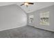 Well-lit bedroom with neutral walls, plush gray carpet, ceiling fan, and two large windows at 6032 Trotters Cir, Fairburn, GA 30213