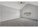 Bright bedroom with neutral walls, plush gray carpeting, and a high vaulted ceiling at 6032 Trotters Cir, Fairburn, GA 30213