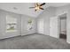 Bright bedroom featuring neutral walls, gray carpeting, a ceiling fan, and two windows for ample natural light at 6032 Trotters Cir, Fairburn, GA 30213