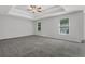Large bedroom features a tray ceiling, ceiling fan, and neutral gray paint at 6032 Trotters Cir, Fairburn, GA 30213