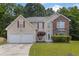 Charming two-story home featuring a blend of vinyl siding and brick accents, complemented by a well-manicured front yard at 6032 Trotters Cir, Fairburn, GA 30213