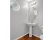 Stylish powder room with pedestal sink and unique round window at 6032 Trotters Cir, Fairburn, GA 30213