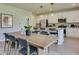 Dining area features modern table and island seating overlooking the stylish gourmet kitchen at 146 Kingsley Way, Acworth, GA 30102