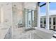 Luxurious bathroom featuring marble walls, a glass shower, soaking tub, and dual sinks at 3107 Peachtree Ne Rd # 2003 Aka Ph3, Atlanta, GA 30305
