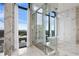 Modern bathroom featuring marble walls, glass-enclosed shower, and freestanding tub with a city view at 3107 Peachtree Ne Rd # 2003 Aka Ph3, Atlanta, GA 30305