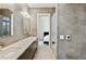 Sleek bathroom features double sinks, modern lighting, and gray tiled walls, offering a luxurious and contemporary feel at 3107 Peachtree Ne Rd # 2003 Aka Ph3, Atlanta, GA 30305