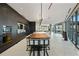Modern kitchen and dining area with sleek dark cabinetry, long dining table, and floor to ceiling windows at 3107 Peachtree Ne Rd # 2003 Aka Ph3, Atlanta, GA 30305
