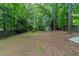 Serene backyard featuring a storage shed and surrounded by lush trees, great for recreation at 8350 Gledstone Way, Fairburn, GA 30213