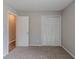 Carpeted bedroom features open closet and doorway at 8350 Gledstone Way, Fairburn, GA 30213
