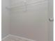 A minimalist walk-in closet provides essential hanging storage for wardrobe organization at 8350 Gledstone Way, Fairburn, GA 30213